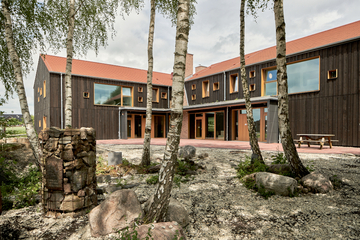 Blick auf den Neubau des Gästehauses mit Holzfassade